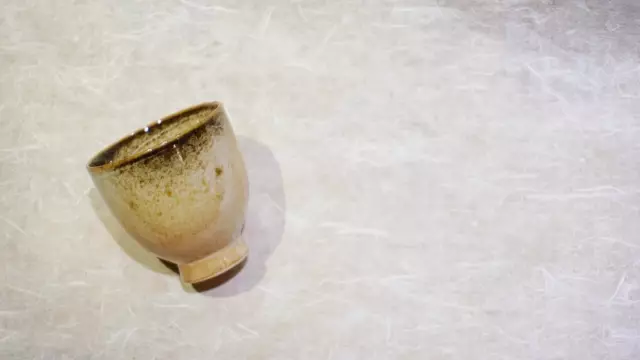 A straight-sided wood-ash glazed cup